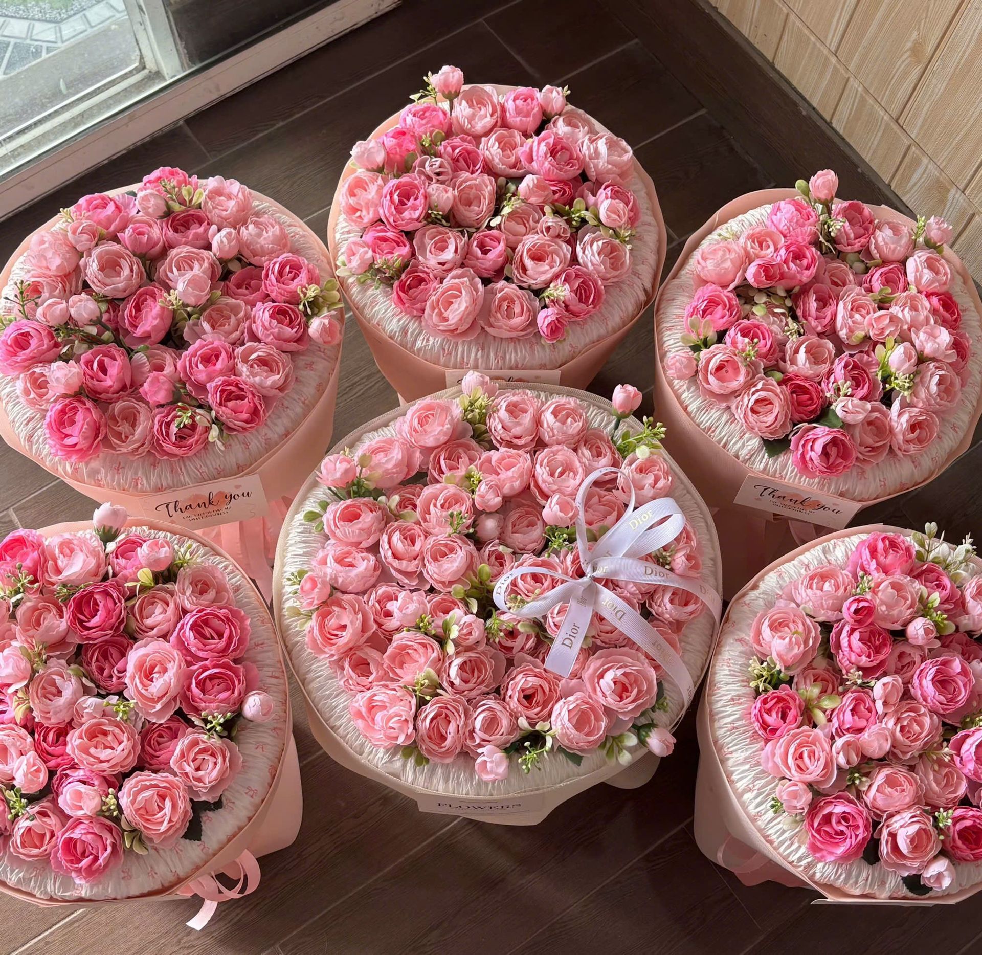 Sáu bó hồng tròn tông hồng đậm nhạt gói giấy hồng, nhìn từ trên xuống